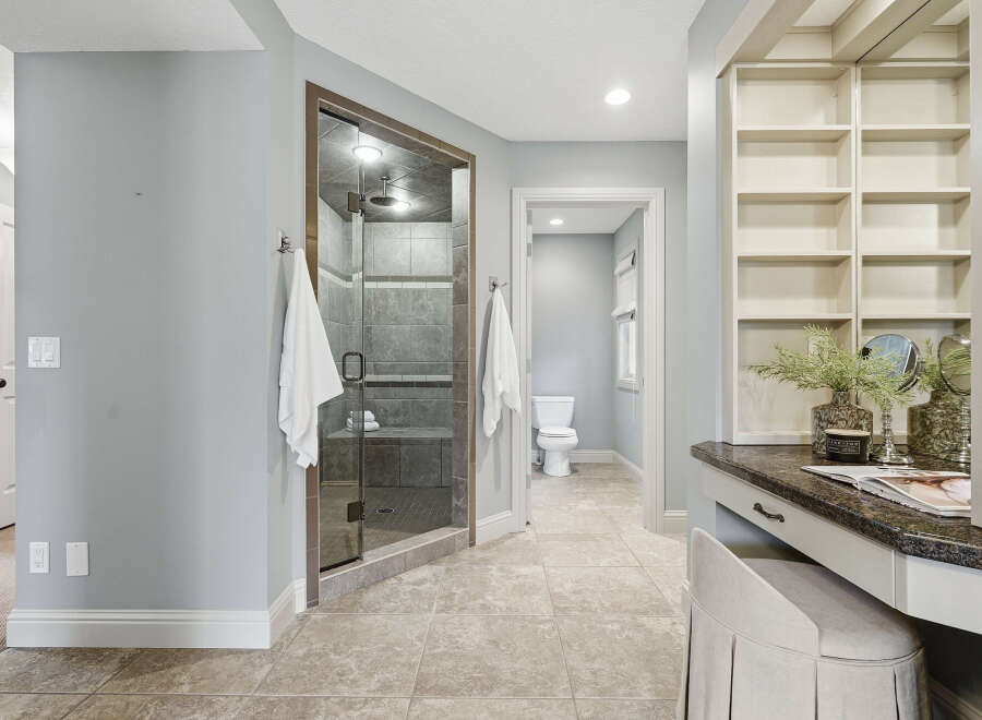 Experience luxury in this spacious bathroom featuring a stunning glass-enclosed shower with modern tile work.