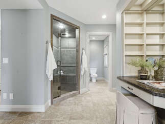 Experience luxury in this spacious bathroom featuring a stunning glass-enclosed shower with modern tile work.