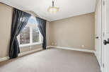 This spacious room features a large arched window with elegant dark curtains, allowing natural light to fill the space.