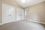 Discover this charming room featuring a vaulted ceiling and ample closet space with double doors.
