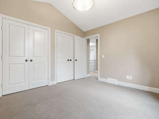Discover this charming room featuring a vaulted ceiling and ample closet space with double doors.