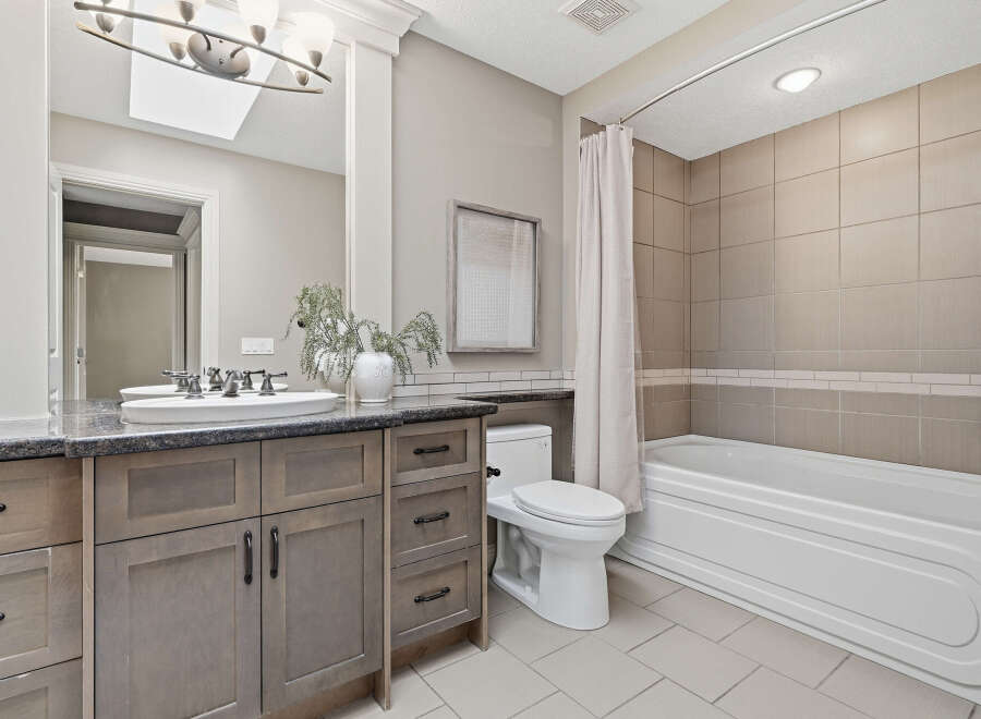This beautifully appointed bathroom features a spacious vanity with ample storage and a sleek granite countertop.
