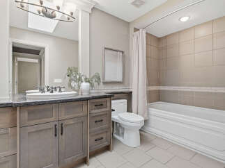 This beautifully appointed bathroom features a spacious vanity with ample storage and a sleek granite countertop.