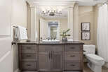 This bathroom features a spacious vanity with ample storage and a granite countertop, complemented by a modern vessel sink and elegant fixtures.