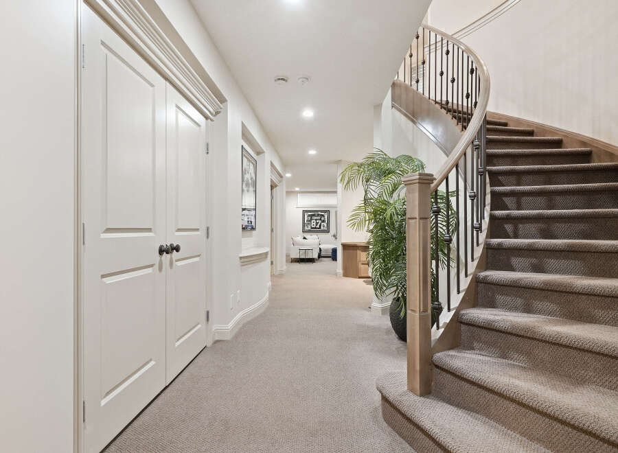 This elegant home features a stunning curved staircase with a wrought-iron railing, leading to the upper levels.
