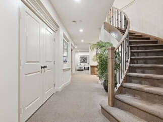 This elegant home features a stunning curved staircase with a wrought-iron railing, leading to the upper levels.