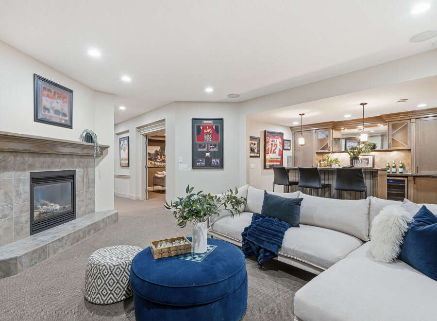 This inviting basement living area features a cozy fireplace with a tile surround, perfect for relaxing evenings.