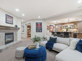 This inviting basement living area features a cozy fireplace with a tile surround, perfect for relaxing evenings.