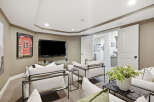 This inviting living room features a large flat-screen TV mounted above a sleek glass shelf, perfect for entertainment.