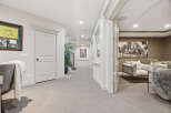 Step into a beautifully finished basement featuring a spacious hallway with elegant trim and a framed golf memorabilia piece.