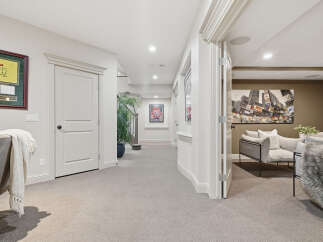 Step into a beautifully finished basement featuring a spacious hallway with elegant trim and a framed golf memorabilia piece.