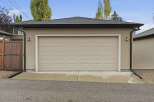 This property features a well-maintained garage with a classic beige sectional door, perfect for protecting your vehicles.