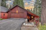 Nestled amidst towering pine trees, this charming red wood-sided home offers a serene mountain retreat.
