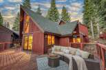Experience mountain living in this stunning A-frame home, featuring a spacious wooden deck perfect for outdoor entertaining.