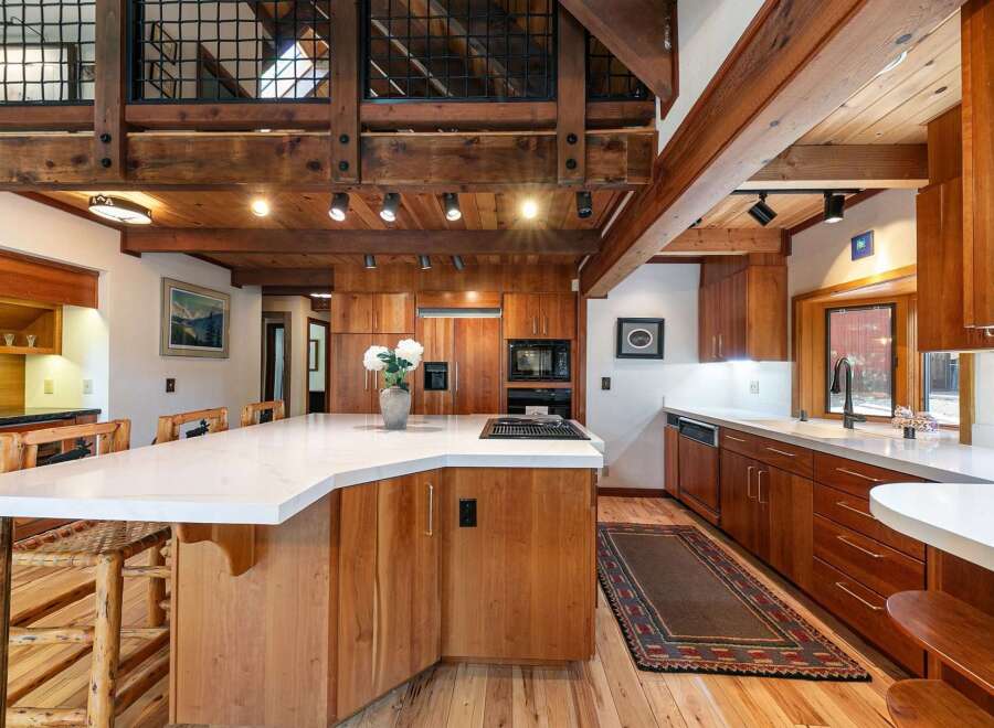 Experience rustic charm and modern convenience in this stunning kitchen, featuring rich wood cabinetry and a sleek quartz island.
