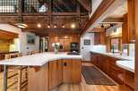 Experience rustic charm and modern convenience in this stunning kitchen, featuring rich wood cabinetry and a sleek quartz island.
