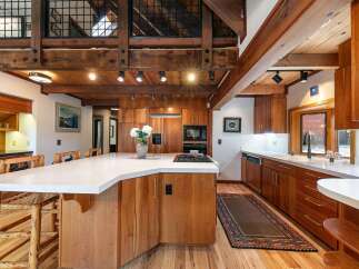 Experience rustic charm and modern convenience in this stunning kitchen, featuring rich wood cabinetry and a sleek quartz island.