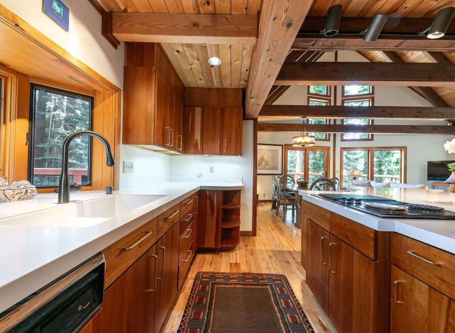 Experience rustic charm in this stunning kitchen featuring rich wood cabinetry and exposed beams.