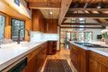 Experience rustic charm in this stunning kitchen featuring rich wood cabinetry and exposed beams.
