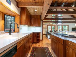 Experience rustic charm in this stunning kitchen featuring rich wood cabinetry and exposed beams.