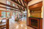 Experience rustic luxury in this stunning living space, featuring a soaring vaulted ceiling with exposed wooden beams and a charming stone fireplace.