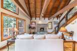 Experience rustic charm in this inviting living room, featuring a magnificent stone fireplace and a soaring wood-beamed ceiling.
