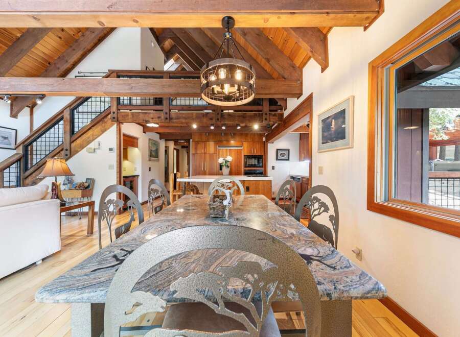 Experience rustic charm in this spacious dining area, featuring a stunning granite-top table with unique animal-themed chairs, perfect for memorable gatherings.
