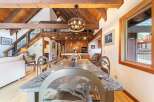 Experience rustic charm in this spacious dining area, featuring a stunning granite-top table with unique animal-themed chairs, perfect for memorable gatherings.