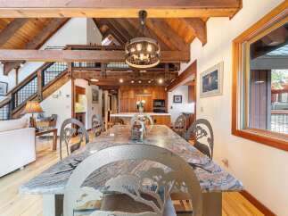 Experience rustic charm in this spacious dining area, featuring a stunning granite-top table with unique animal-themed chairs, perfect for memorable gatherings.