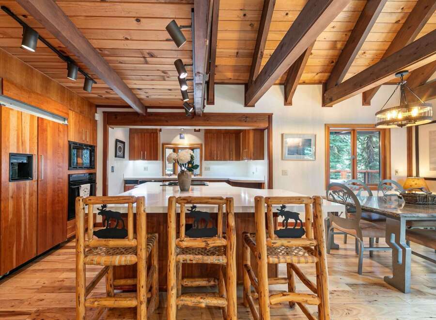 Experience rustic charm in this spacious kitchen and dining area, featuring warm wood finishes, exposed beams, and a large island perfect for entertaining.