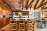 Experience rustic charm in this spacious kitchen and dining area, featuring warm wood finishes, exposed beams, and a large island perfect for entertaining.