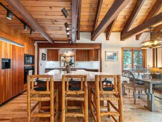 Experience rustic charm in this spacious kitchen and dining area, featuring warm wood finishes, exposed beams, and a large island perfect for entertaining.
