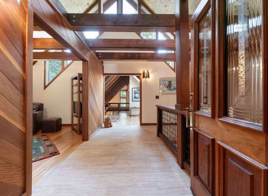 Step into a warm and inviting entryway featuring rich wood paneling and exposed beams that create a cozy, rustic ambiance.