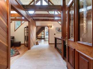 Step into a warm and inviting entryway featuring rich wood paneling and exposed beams that create a cozy, rustic ambiance.