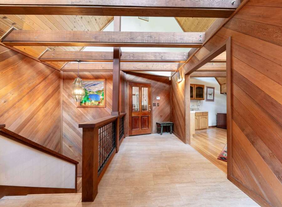 Step into a warm and inviting entryway featuring rich wood paneling and exposed beams, creating a rustic yet elegant ambiance.
