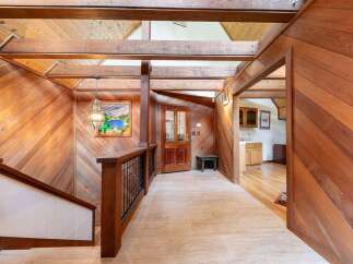 Step into a warm and inviting entryway featuring rich wood paneling and exposed beams, creating a rustic yet elegant ambiance.