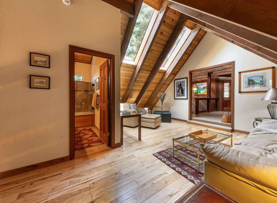 Discover this charming attic living space featuring a cozy seating area with skylights that flood the room with natural light.