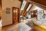 Discover this charming attic living space featuring a cozy seating area with skylights that flood the room with natural light.