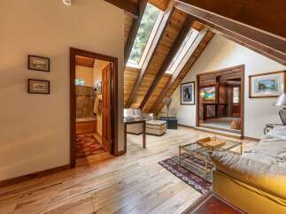 Discover this charming attic living space featuring a cozy seating area with skylights that flood the room with natural light.