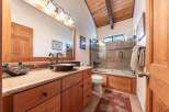 This charming bathroom boasts a rustic aesthetic with its exposed wooden beams and natural wood cabinetry.
