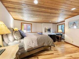 Experience ultimate comfort in this inviting bedroom, featuring a plush bed adorned with decorative pillows and a cozy duvet.