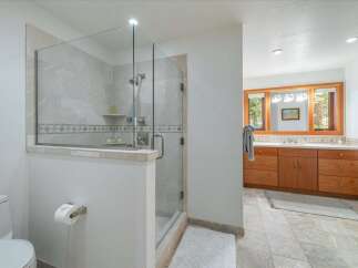 Experience luxury in this spacious bathroom featuring a modern glass-enclosed shower with elegant tilework.