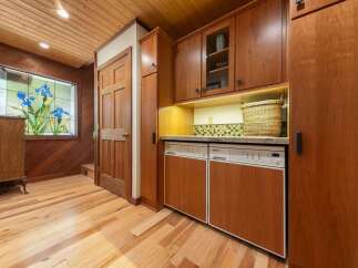Step into a charming entryway featuring warm wood paneling and a beautiful stained-glass window depicting blue irises.