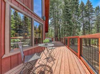 Enjoy the serene mountain setting from this charming wooden deck, perfect for outdoor relaxation.