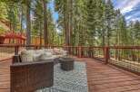 Enjoy the serene mountain lifestyle on this expansive deck, perfect for outdoor entertaining amidst towering pine trees.
