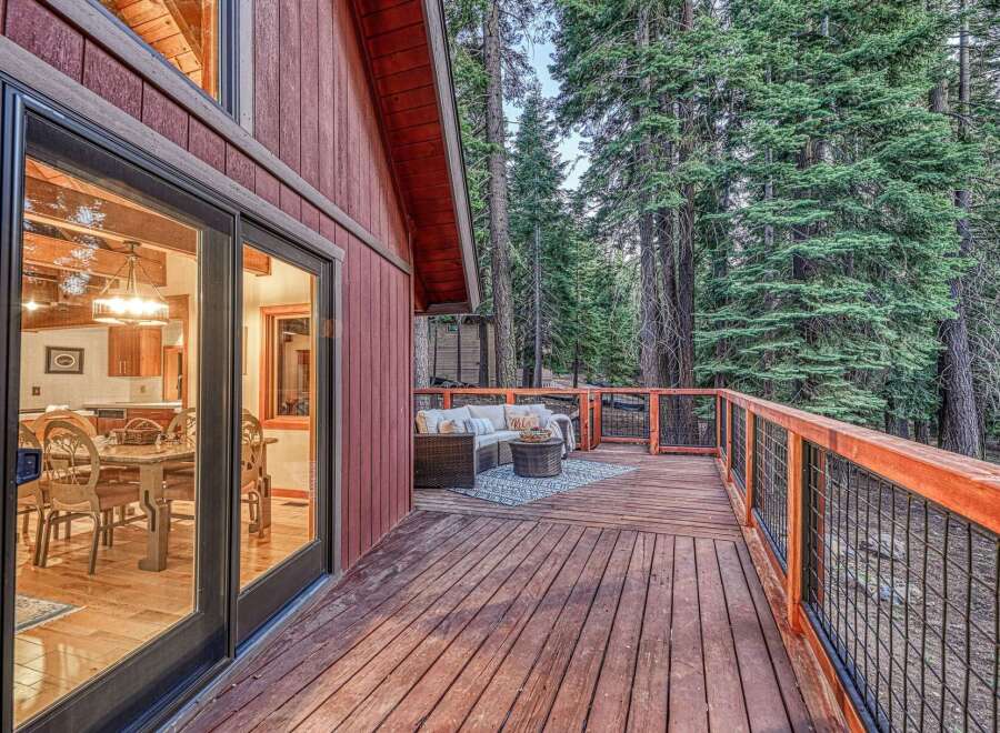 Enjoy the serene mountain lifestyle with this charming cabin featuring a spacious wooden deck perfect for outdoor entertaining.