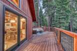 Enjoy the serene mountain lifestyle with this charming cabin featuring a spacious wooden deck perfect for outdoor entertaining.