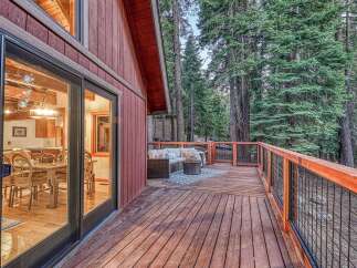Enjoy the serene mountain lifestyle with this charming cabin featuring a spacious wooden deck perfect for outdoor entertaining.