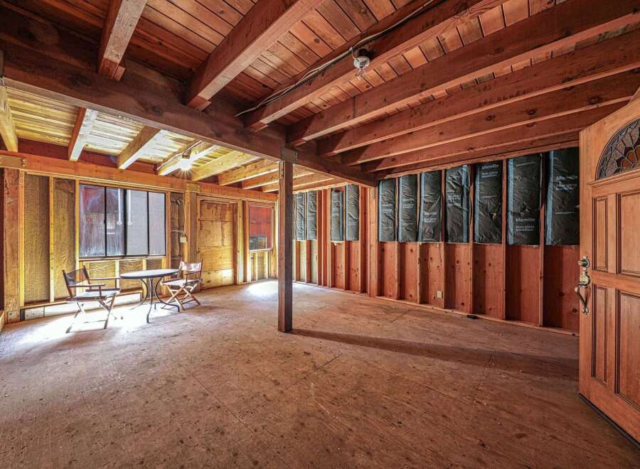 Explore the potential of this unfinished space, featuring exposed wooden beams and a rustic charm.