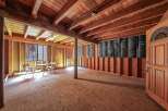Explore the potential of this unfinished space, featuring exposed wooden beams and a rustic charm.